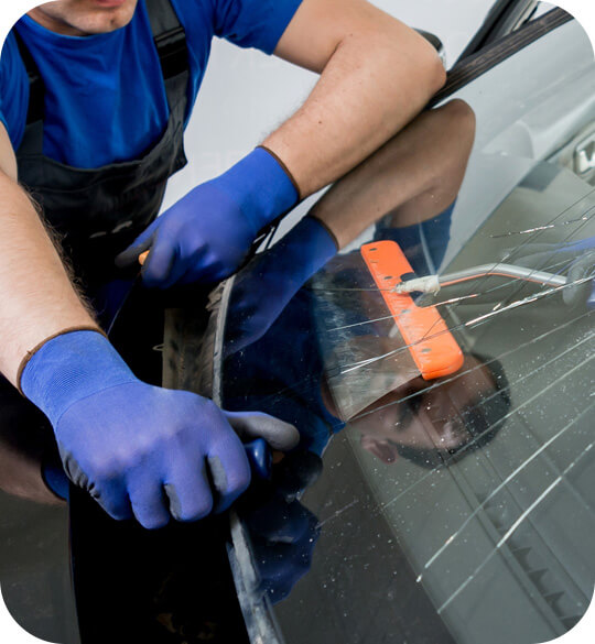 Réparation de pare-brise fissuré mené par un technicien en atelier mécanique